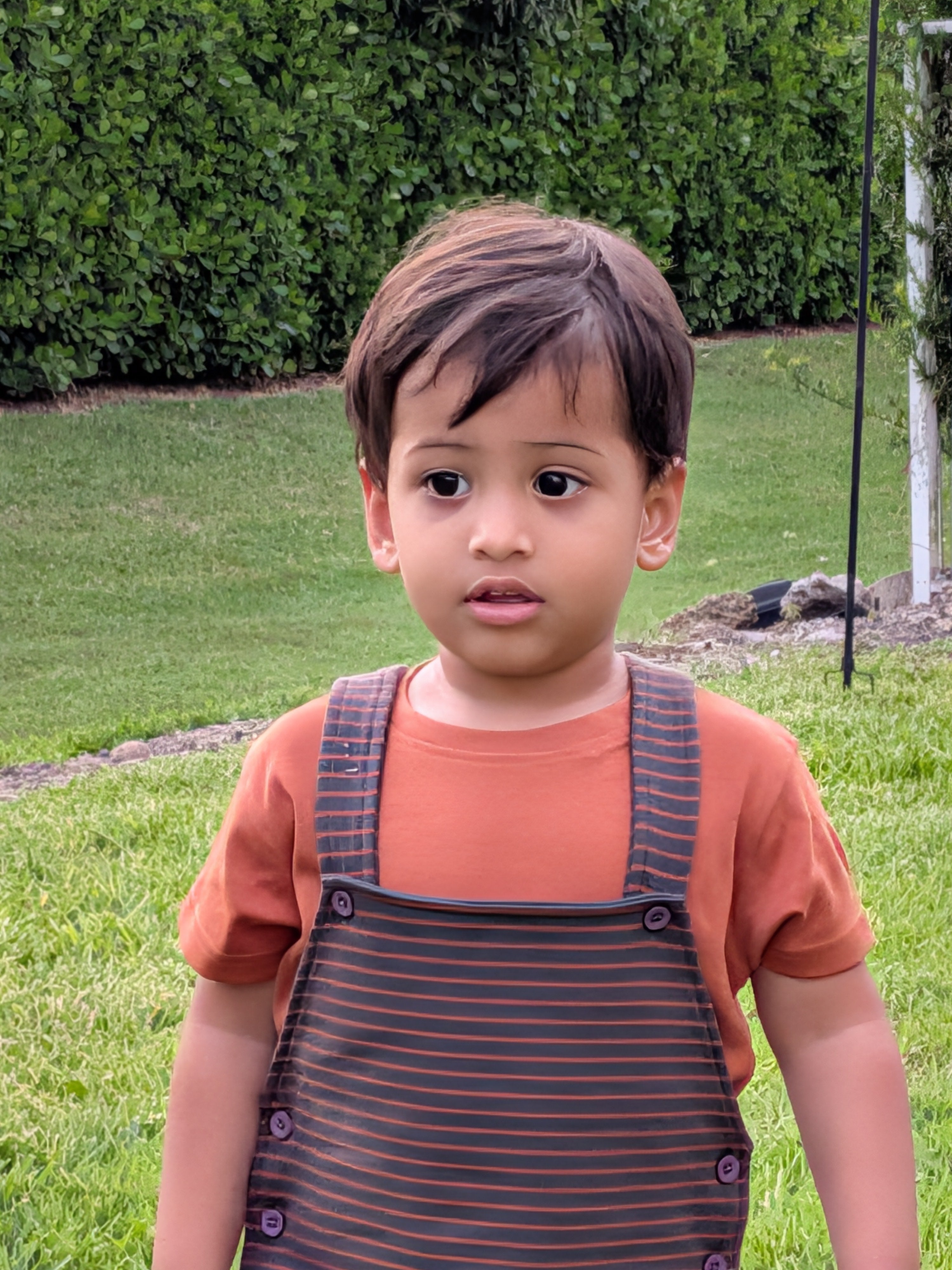 Outdoor portrait of toddler in MulmulBaby Burnt Orange Stripes dungaree overalls set