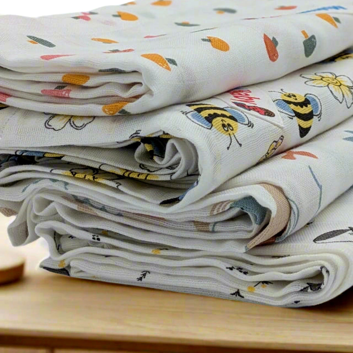 Close view of the folded edges and stitched hem of a cream mulmul muslin baby towel.