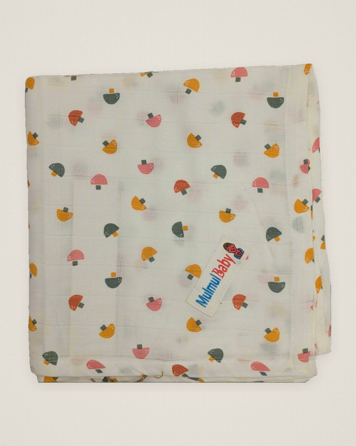 A single cream mulmul muslin baby towel on a plain background with its woven label visible.
