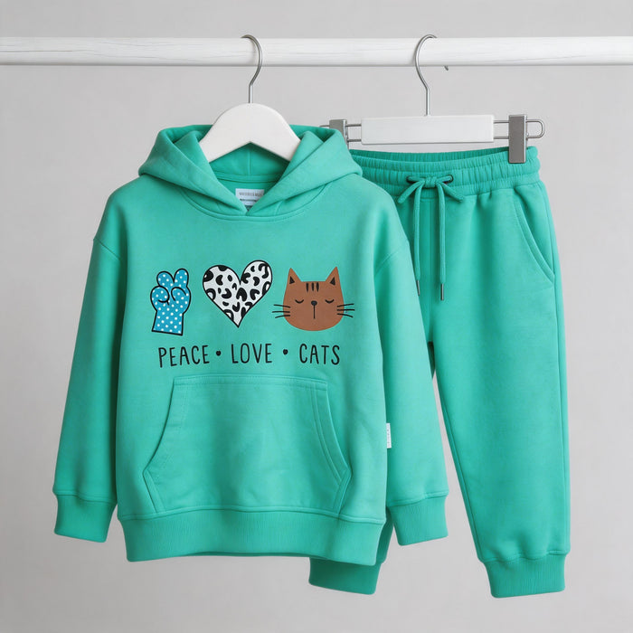 The mint Peace Love Cats cotton hoodie and matching joggers on wooden hangers against a pale wall.