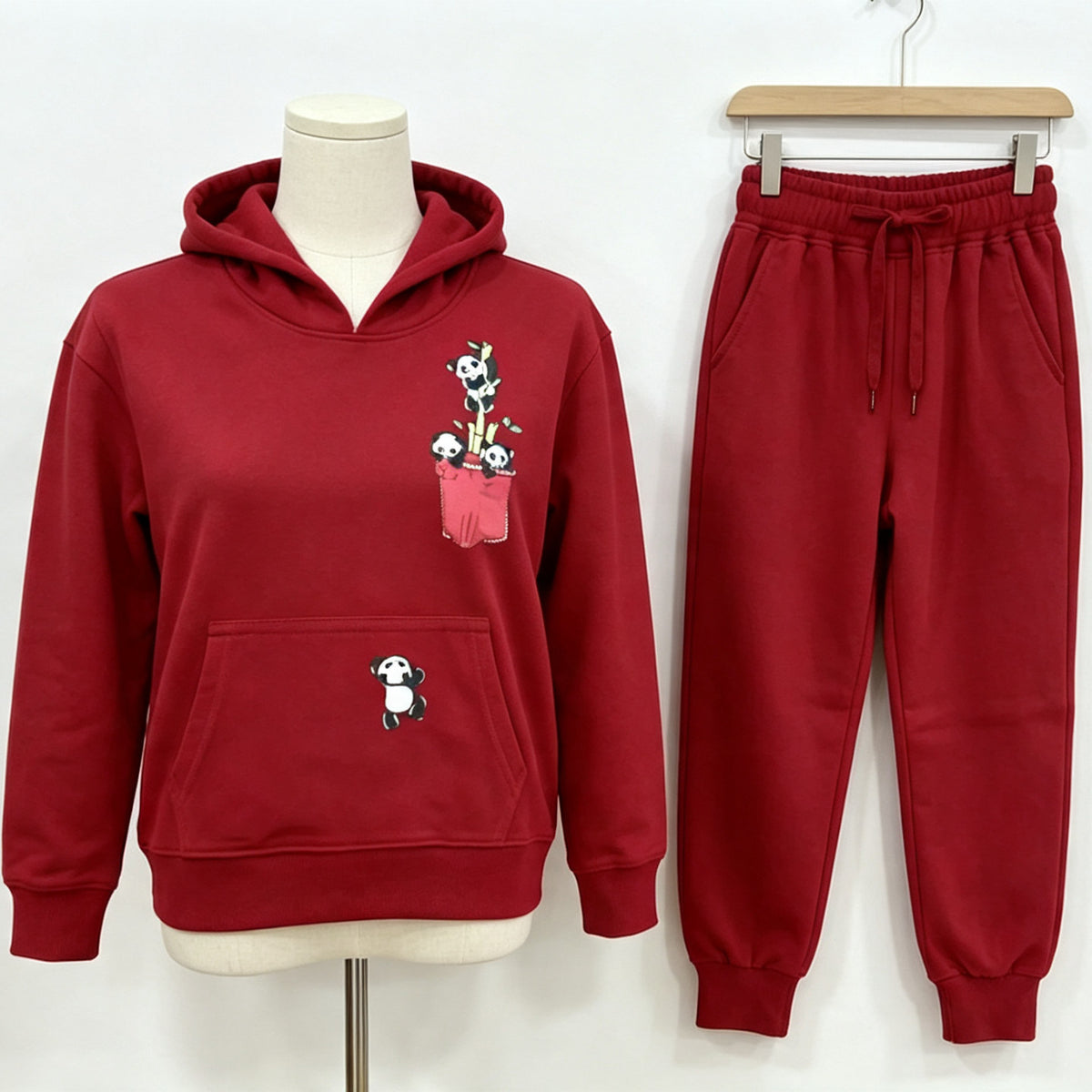 The red Panda Pocket cotton hoodie on a mannequin with the matching joggers beside it.