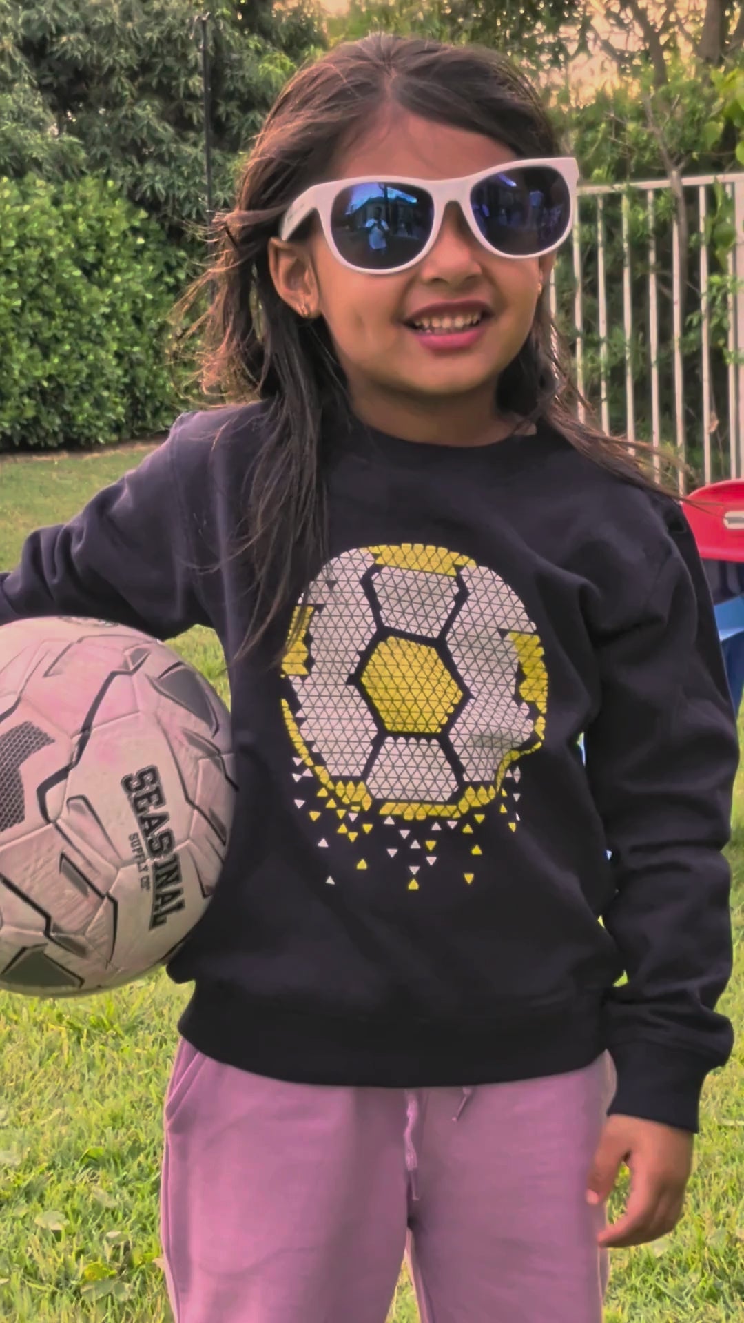 Real child playing soccer in the Soccer Time organic cotton sweatshirt