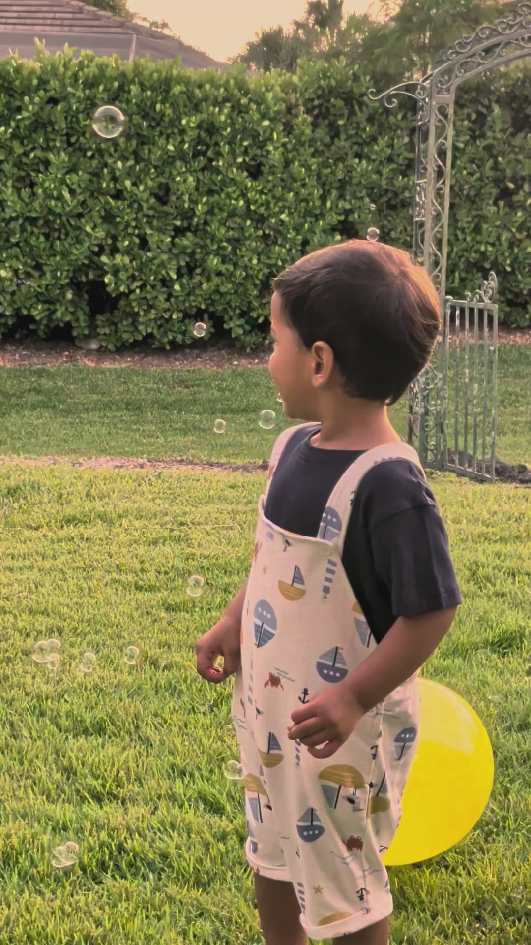 Real child running through bubbles in the muslin shirt and short set