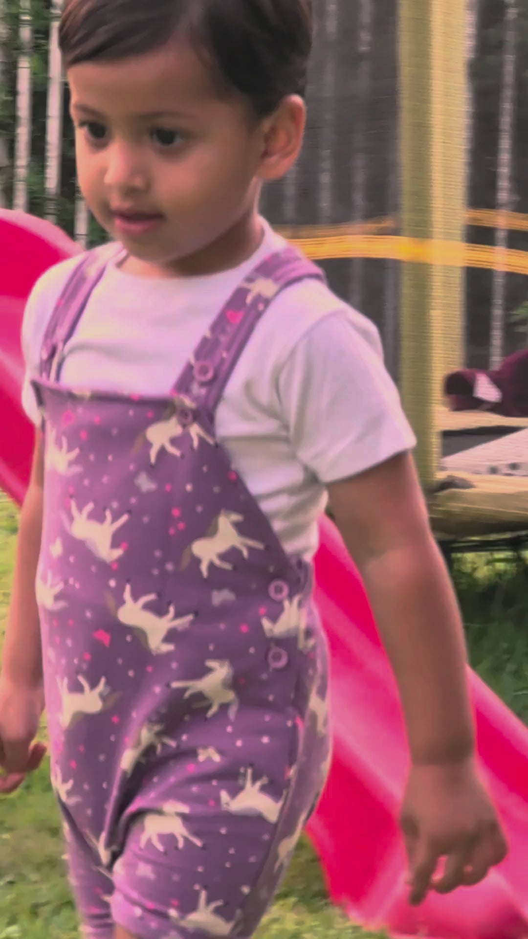 Real toddler wearing the Lavender Horses muslin dungaree set at sunset